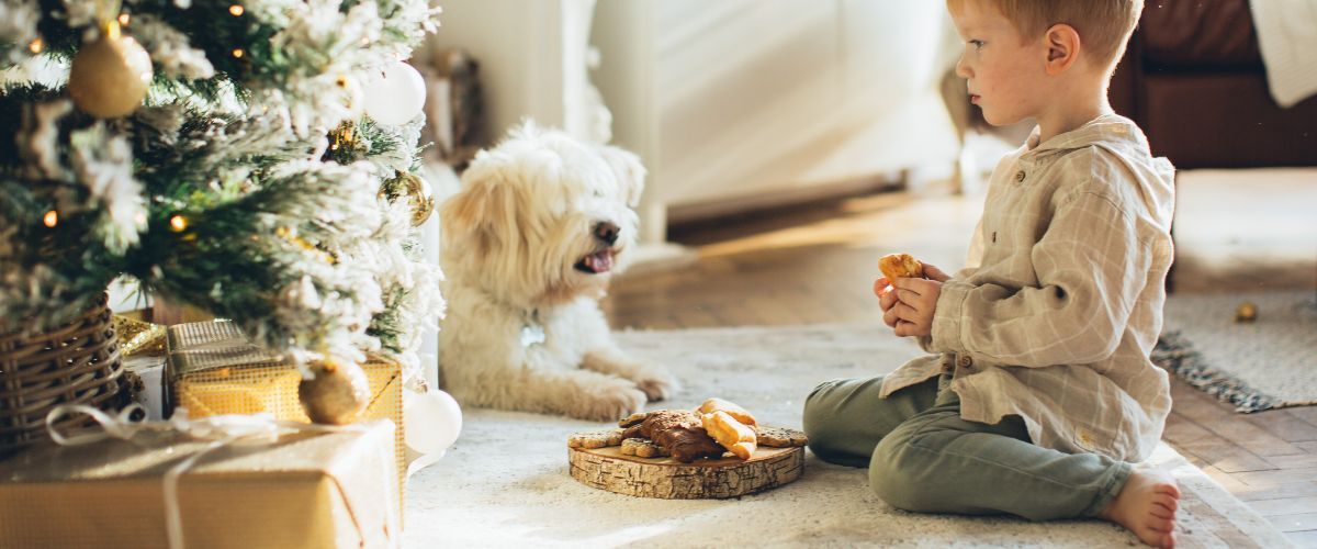 Hond en kind bij de kerstboom